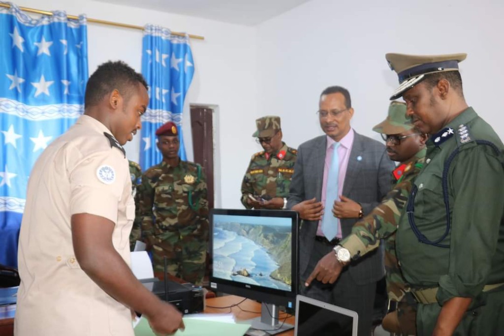 Mohamed Abdullahi Khalif oo Mudane Xasan Xuseen Xaaji, Wasiirkii Gaashaandhigga, warbixin ugu jeedinaya agagaarka shaashad intii booqashada rasmiga ah ka socotay Xafiiska Xeer-ilaalinta Ciidamada ee Muqdisho, 4 Febraayo 2021.